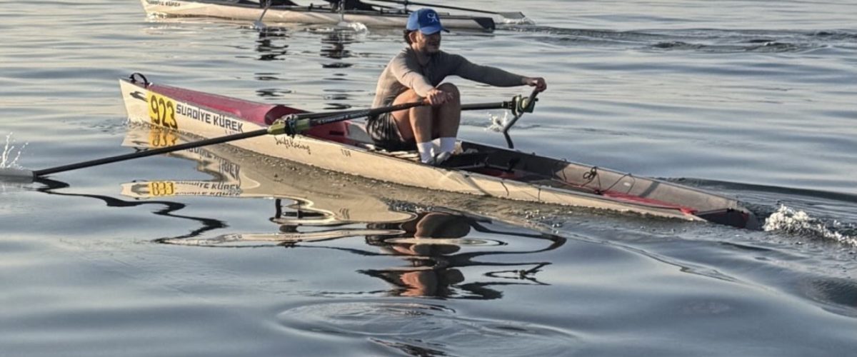 Suadiye Kürek sporcusu açık suda single sculls antrenmanı yaparken — sabah saatlerinde sakin deniz ve Adalar silüeti