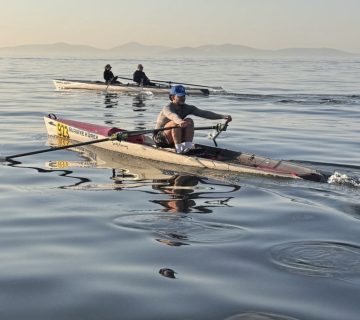 Suadiye Kürek sporcusu açık suda single sculls antrenmanı yaparken — sabah saatlerinde sakin deniz ve Adalar silüeti