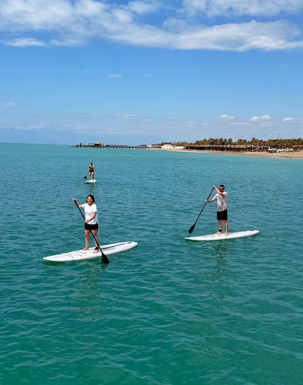 Açık denizde SUP board eğitimi alan grup