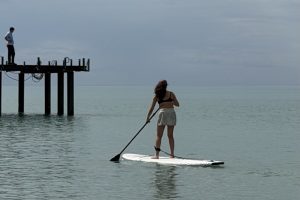 Antalya kürek kampında SUP eğitimi – Suadiye Kürek Kulübü katılımcısı sakin denizde iskele önünde SUP tahtasında